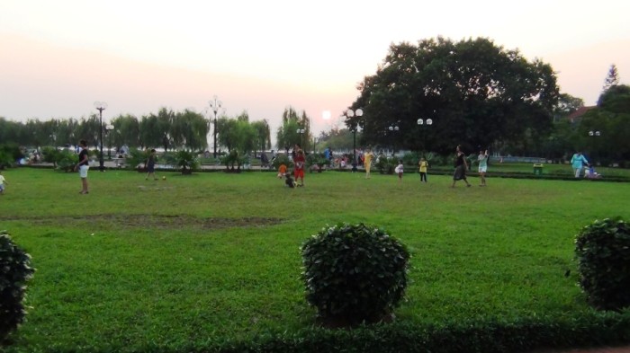 夕暮れ迫る緑地の公園で遊ぶ国際色豊かな子供たち