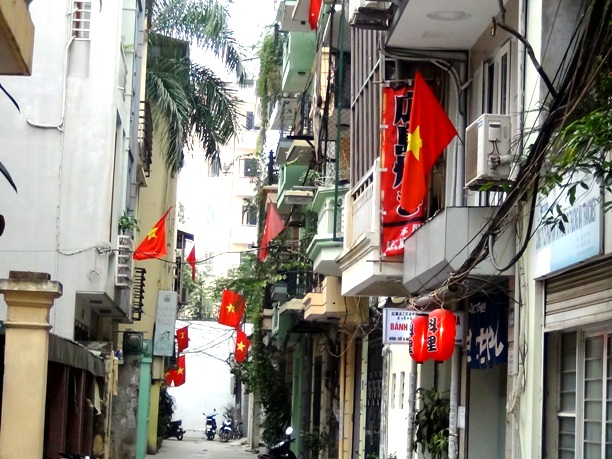 国民の祝日に必ず国旗を揚げるベトナムの人々
